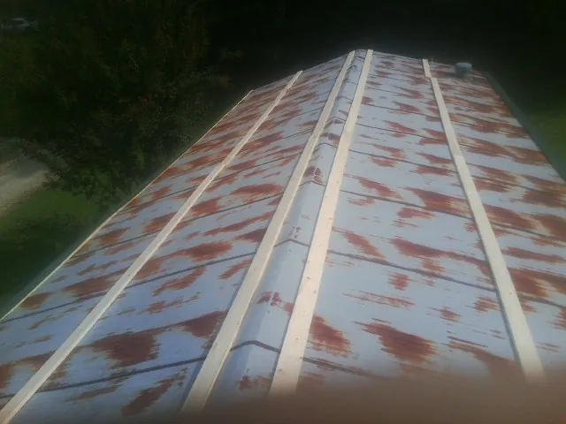 Rusted metal roof panels with new wood purlins before replacement — Storm Damage Roof Repair in Sunland by Roofing Brothers